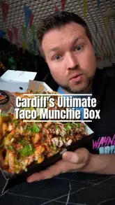 A creator reviews a 'Munchie Box' from Taco Bull in Cardiff, showcasing the variety of items included such as birria tacos, chicken tenders, and a smash burger. The video features the venue's interior and the creator's honest reaction to the food.
