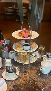 A short, aesthetic montage showcasing an afternoon tea service at The London Carriage Works, featuring close-ups of tea pouring, prosecco, and various pastries and savoury items.