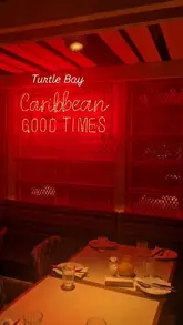 A short, energetic montage showcasing the atmosphere at a Turtle Bay restaurant on a Saturday night. The video features clips of the interior, a live saxophonist, a bartender preparing cocktails, a DJ, and a table spread of Caribbean-inspired dishes and drinks.