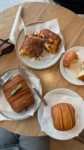 A short, engaging reel showcasing a variety of unique, fusion-style pastries at a London bakery. The video features close-up shots of the pastries being cut open to reveal their fillings, highlighting the texture and quality of the food.