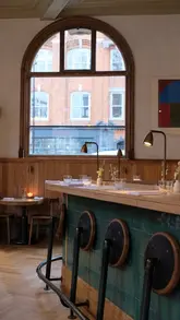 A montage of shots showcasing the interior, open kitchen, and Mediterranean-inspired dishes and wine at Morchella restaurant in London.