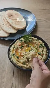 A concise, step-by-step recipe video demonstrating how to make baba ganoush by fire-roasting eggplants on a gas stove, blending with tahini, lemon, and garlic, and serving with toasted pitta.