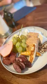 A montage video showcasing a Greek wine tasting experience at a wine bar, featuring various wines, a charcuterie board, and a beef stifado dish.