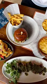 A promotional video for All Bar One's 'Bottomless Fridays' offer, featuring a variety of dishes including a burger, steak, calamari, and mac and cheese, alongside cocktails and prosecco.