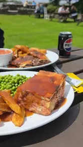 A review of Penshaw Tea Rooms, highlighting the comfort food (pies, chips, peas, beans) and the busy, popular atmosphere. The video includes shots of the food, the menu, the interior, and the outdoor seating area.