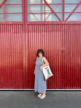 A clean, well-composed lifestyle shot featuring a visitor standing in front of a striking red corrugated metal door at the M Shed museum in Bristol, promoting the Aardman animation exhibition.