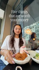 A creator presents a list of recommended dishes at Sticks'n'Sushi, holding up each plate to the camera while listing the items and their prices.