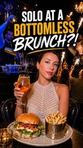 A promotional shot for a bottomless brunch experience, featuring a woman dining solo in a dimly lit, party-atmosphere venue. The image highlights the interactive nature of the brunch, including cocktails and a burger meal, set against a backdrop of a lively, music-focused environment.