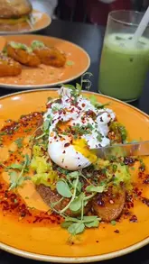 A short, punchy montage showcasing various brunch and lunch items at Davey's, including avocado toast, a loaded grilled cheese sandwich, a bagel, and matcha drinks. The video focuses on close-up, high-quality shots of the food to entice viewers.