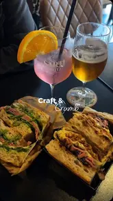 A short montage showcasing sandwiches, cocktails, and beer at Craft & Crumb, highlighting the food presentation and the venue's interior atmosphere.