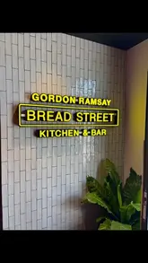 A video tour of Gordon Ramsay's Bread Street Kitchen & Bar, featuring shots of the interior decor and a selection of dishes including a sandwich, butter chicken, and desserts.