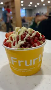 A creator visits a Frurt frozen yogurt stand located inside a Morrisons in Leeds, showing the selection of toppings and the final product, followed by a review of the froyo and an iced latte in her car.
