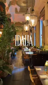 A visually polished showcase of Idalia, a restaurant in West London, highlighting its opulent interior design, cocktails, and various dishes including salmon, fried chicken, risotto, steak, and tiramisu.
