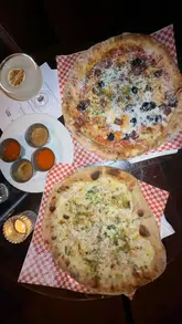 A creator visits The Old Queen's Head in Islington for a Scottish-themed supper club collaboration between Hot Saint and Auld Hag, featuring unique dishes like haggis bon bons, Scottish breakfast pizza, Cullen Skink pizza, and a deep-fried Mars bar.