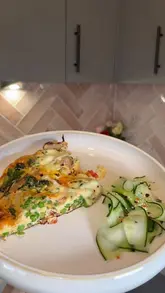 A home cooking tutorial demonstrating how to make a sausage, vegetable, and cheese egg bake (frittata). The video follows a clear step-by-step process from chopping ingredients to cooking in the pan and finishing under the grill.