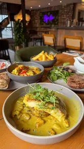 A high-quality, polished video showcasing a new menu at Beija Flor, featuring close-ups of various dishes like steak, seafood, and curry, alongside shots of the restaurant's interior.