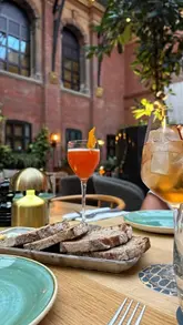 A montage video showcasing the interior, cocktails, and food offerings at Oz & Isle, a restaurant and bar located within a historic building in Cambridge.