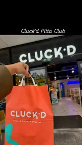 A short promotional video showcasing the new 'Pitta Club' menu at Cluck'd in Milton Keynes, featuring exterior shots, the ordering kiosk, interior decor, and the final food presentation.