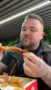 A creator reviews a takeaway venue called Caledonia Chicken and Ribs, comparing it to a previous bad experience at a different location. He samples the chips, ribs, and chicken, providing a positive review of the food quality and value.