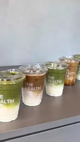 A short, aesthetic montage featuring a collaboration between a clothing brand and a cafe, showcasing iced matcha and coffee drinks alongside a clothing rack.