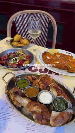 Juicy rotisserie chicken with Cafe de Paris butter, creamy hummus, halloumi kataifi, and tahini cookie at Toum, Mayfair.