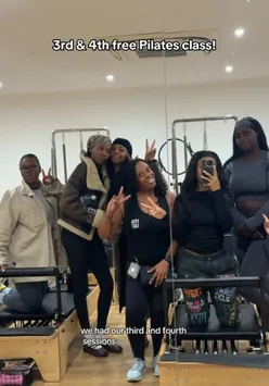 Celebrating a fitness achievement with friends at a reformer Pilates class, showcasing camaraderie and wellness.