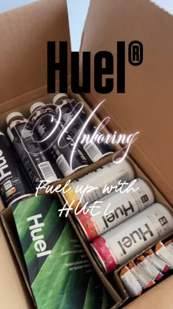 Unboxing a Huel starter kit with shakes, snacks, and vitamins, showcasing a healthy lifestyle journey.