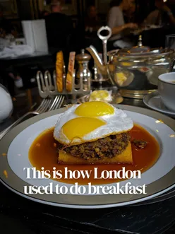 Elegant breakfast at The Wolseley in London, featuring duck eggs on fried bread and haggis with whisky sauce.