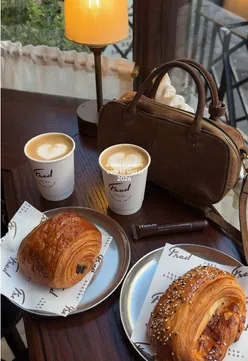 Interior of Fred Bakery in Oxford Circus, showcasing a cozy coffee spot with pastries and stylish decor.