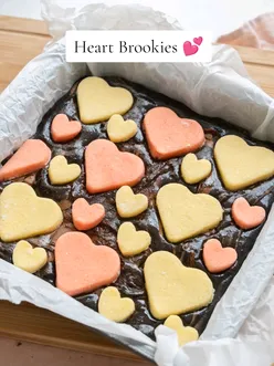 The cutest valentines bake. Recipe below 👇🏼  For the cookie:  240g plain flour 1 tsp baking powder 100g caster sugar 3 tbsp icing sugar 115g unsalted butter, 1 egg 1 tsp vanilla extract For the brownies: 140g butter, cubed 200g light brown sugar 150g chocolate, chopped 60g cocoa powder 100g plain flour 2 medium eggs 150g chocolate chips Preheat the oven to 180c and line an 8x8" baking tin. In a bowl, whisk together flour and baking powder. Add in the butter and sugars. Use your hands to rub the butter into the mix to create a fine breadcrumb texture. Mix in the egg and vanilla until smooth, and a dough forms. Divide into 2 and colour one half pink.  On a lightly floured surface, roll to 1.5cm thick and cut out hearts. Place onto a lined baking tray and pop into the freezer for 30 mins. In a large pan, add the butter, sugar and chocolate and melt over a gentle heat. Once melted leave to cool slightly. Add in the cocoa powder, flour and eggs. Add in the chocolate chunks and chips. Stir until fully combined. Pour into the prepared tin, add the cookies on top, cover with baking paper on top and bake for 40 minutes. The edge should be set but soft in the middle. Leave to cool completely before eating. #baketok #bakingtiktok #valentinesday 