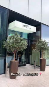 A short, engaging reel showcasing a visit to Kouba in Deansgate, Manchester. The video highlights the venue's aesthetic interior, the brunch menu, and unique offerings like coffee on tap and a sheesha lounge.
