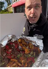 A high-energy food review of a large 'munchbox' takeaway from Ranya Shawarma Grill, featuring a variety of grilled meats, chips, and sides.