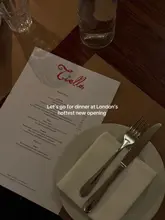 A moody, atmospheric shot of a menu at Tiella, a new restaurant on Columbia Road. The lighting is low and intimate, focusing on the menu text and table setting.