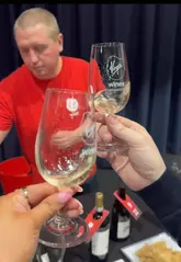 The video is a vlog-style review of a Virgin Wines tasting event in Manchester. The creators walk through the venue, sampling various wines, interacting with the staff, and enjoying the cheese and snacks provided. The video highlights the social nature of the event and the opportunity to taste different wine varieties.