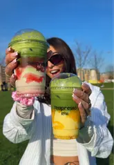 A creator visits Teapresso in Leeds to review their matcha drinks and ice cream. She showcases the strawberry matcha latte, mango coconut matcha latte, and a scoop of ice cream, providing her taste test and positive feedback.