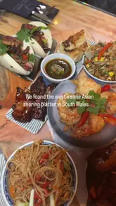 A montage video showcasing an Asian-inspired sharing platter and various desserts at La Luna restaurant, featuring close-up shots of dishes like crispy beef, bao buns, and a chocolate dipping pot.