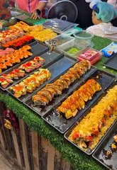 A fast-paced vlog-style video touring the Ao Nang Night Market in Krabi, Thailand. The creator samples various street food items including sushi, blow-torched steak, corn dogs, gyoza, pizza, and mochi, while also highlighting the market's atmosphere and live entertainment.