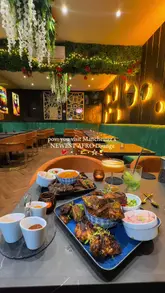 A short, energetic video showcasing the interior, food, and drinks at Kaijah Lounge in Manchester. The video features quick cuts of grilled meats, jollof rice, cocktails, and the venue's aesthetic decor.