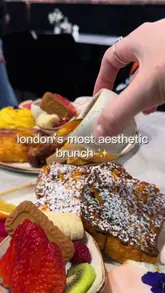 A short, visually-focused reel showcasing a brunch cafe in London. The video features close-up, slow-motion shots of various brunch items like French toast, eggs, bacon, and fruit, followed by a brief pan of the cafe's interior.