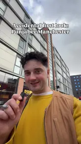 The video is a first-person vlog tour of a new Indian deli called Punjabee in Ancoats, Manchester. The creator walks through the area, introduces the venue, highlights the interior design, showcases various food items like samosas, chai, curries, and wraps, and provides a taste test of a wrap.