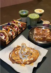 A visually appealing showcase of a dessert counter in Birmingham, featuring close-ups of tiramisu French toast, taco pancakes, cookie dough, and matcha drinks, set within a vibrant food court environment.