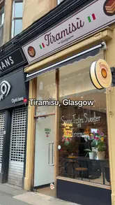 The video is a vlog-style review of a dedicated tiramisu shop in Glasgow. The creator takes the viewer from the exterior of the shop, through the menu and display case, to the final taste test of the product.