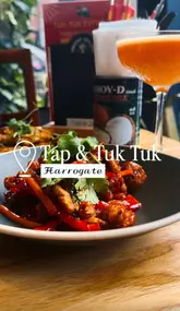 A short, polished montage showcasing a variety of fusion dishes and cocktails at Tap & Tuk Tuk in Harrogate. The video features close-up shots of food being served and manipulated, highlighting the presentation of the meals.