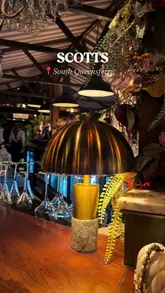 A short, vlog-style video showcasing a visit to Scotts in South Queensferry, featuring shots of the interior, various dishes like macaroni cheese and tacos, cocktails, and a night-time view of the bridge.