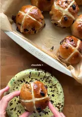 A step-by-step recipe tutorial for chocolate and orange hot cross buns, featuring the creator demonstrating the mixing, kneading, proving, and baking process.