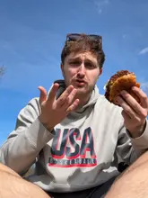 A charismatic, handheld vlog-style review of Side Street Burger in Edinburgh. The creator walks to the venue, orders a barbecue chicken tender burger and a double slider, then takes them to a nearby park to eat. The video features close-ups of the food, a genuine reaction to the taste, and an unexpected, charming interaction with a puppy.