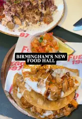 A creator visits Alfred Works food hall in Digbeth, Birmingham, providing a quick tour of the venue and reviewing dishes from two vendors: Baity (Palestinian chicken shawarma) and Fuego 1987 (chicken birria tacos). The video highlights the variety of food options and the bar area, suggesting it as a good spot for a night out.
