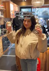 A short video featuring a creator visiting an Amorino gelato shop, highlighting that all their ice cream flavours are gluten-free. The video includes shots of the gelato display, the signage regarding allergies, and the creator enjoying the product.