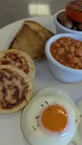 A creator reviews a 'fry up' breakfast at Harvest Jack's, highlighting the homemade potato and soda bread. The video features close-up shots of the meal and the creator eating it, providing a simple, honest review of the food quality.