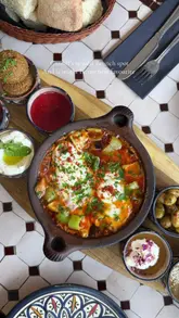 A short, aesthetic reel showcasing a brunch experience at Casablanca in Cardiff. The video features a variety of shots, including the restaurant's interior decor and a detailed look at a Mediterranean-style brunch platter, including shakshuka, fresh bread, and various dips.